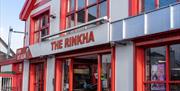 Close up of the exterior of the Rinkha building, painted red and white with sign.