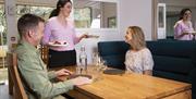 Image of a couple in a restaurant with a waiter bringing there food