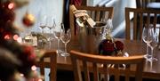 A table set with a wine bottle in an ice bucket and glasses.