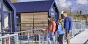 A family going through the gate at the boat glamping pods