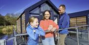 A family outside the house boat glamping pods at Ballyronan Marina