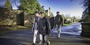 Family walking on a path with castle ruins in the background