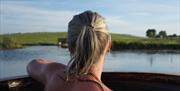 A lady enjoying the view over the waters from the hot tub