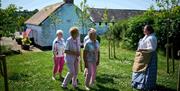 Group of people walking through garden at Arthur Cottage