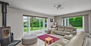 Photograph of open plan living area with double aspect double doors open into garden