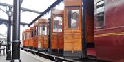 steam train stationary at Whitehead with 8  carriage doors opening onto the platform