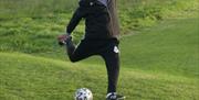 man kicking a ball at newtownabbey footgolf