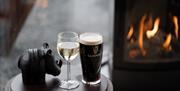 Pint of Guinness and glass of wine on coffee table with stove in background