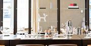 A restaurant table set with wine glasses in front of a shelving unit.