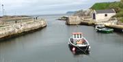 A boat tied to the docks at Ballintoy Harbour.