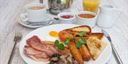 Ulster Fry servied at Ross Park hotel with bacon, sausages, potato bread, soda bread, mushrooms, fried egg and tomato with sauce sides served on white