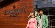 Couple walks outside the Echlinville Distillery in the sunshine