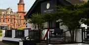 Exterior of the pub with the hotel in the background