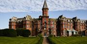 Image of Slieve Donard hotel from the grounds. Shows a Victorian sandstone building.