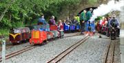 a group of children and adults on a small train