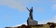 Manannan Mac Lir statue and blue sky in the background.