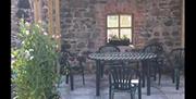 Outdoor seating area with garden furniture and a window.