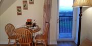 Table and chairs with external door framing pretty view