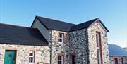 Front exterior view of stone cottages.