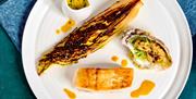 A plate with a pan-seared fillet of hake, a tempura oyster in the half-shell, and roast vegetable.