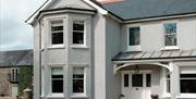 Front of large detached house with courtyard in background