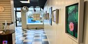 Interior of the Gallery Whitehead - black and white checked floor with white walls and framed images.