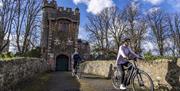 Two cyclists on the bridge that leads to the Barbican Gatelodge
