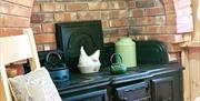 Image shows Aga in kitchen area with explosed brickwork surrounding it