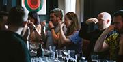 Group of five men and women holding their nose doing taste test