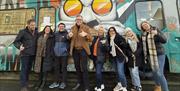 Group shot outside of pyke n pommes double decker bus restaurant