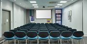 Photo of a meeting room in Holiday Inn Express Belfast City, view from the back of the room. It is set up theatre style with multiple rows of chairs.