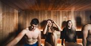 4 people relax in the sauna