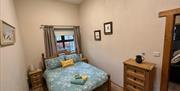 Double bedroom with a chest of drawers and a window.