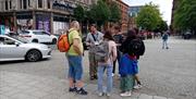 A tour guild leading a group outside of the city centre.