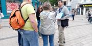 A tour guide with a map of Northern Ireland in the city centre.