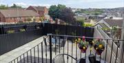 Urban paved back garden with garden furniture, decorated with flower pots.