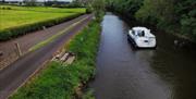 Image of cruise boat on the water beside tow path