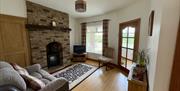 Living room with a brick fireplace, sofa, TV and chair