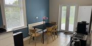 Kitchen with kettle, toaster, coffee maker, fridge/freezer and table
