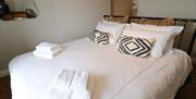 Master bedroom, showing bed dressed with towels on top and fairy lights on headboard.