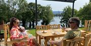 Young couple with child enjoying breakfast on the patio overlooking the lake.