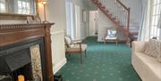 Reception room showing open tread stairs to the attic bedroom, sofa and armchairs.