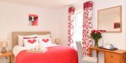 king size bed with dressing table and chair with a mirror on wall