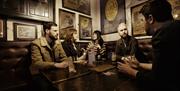 group of people at a table inside the bar chatting and enjoying drinks.