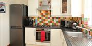 Titanic Kitchen fully fitted with a fridge, hob/oven, microwave, sink, coffee maker and a kettle.