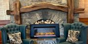Two chairs either side of stone fireplace