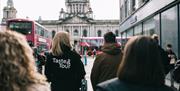 Guests and Tour guides with their back to the camera walking towards Belfast City Hall