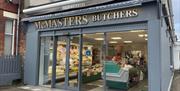 Grey shop frontage of McMasters Butchers in Whitehead