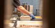 Photo of a chef bringing a tray of fresh potato breads to the hot plate part of the breakfast buffet.