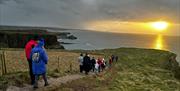 Visitors admiring the sunrise on the Causeway cliffs